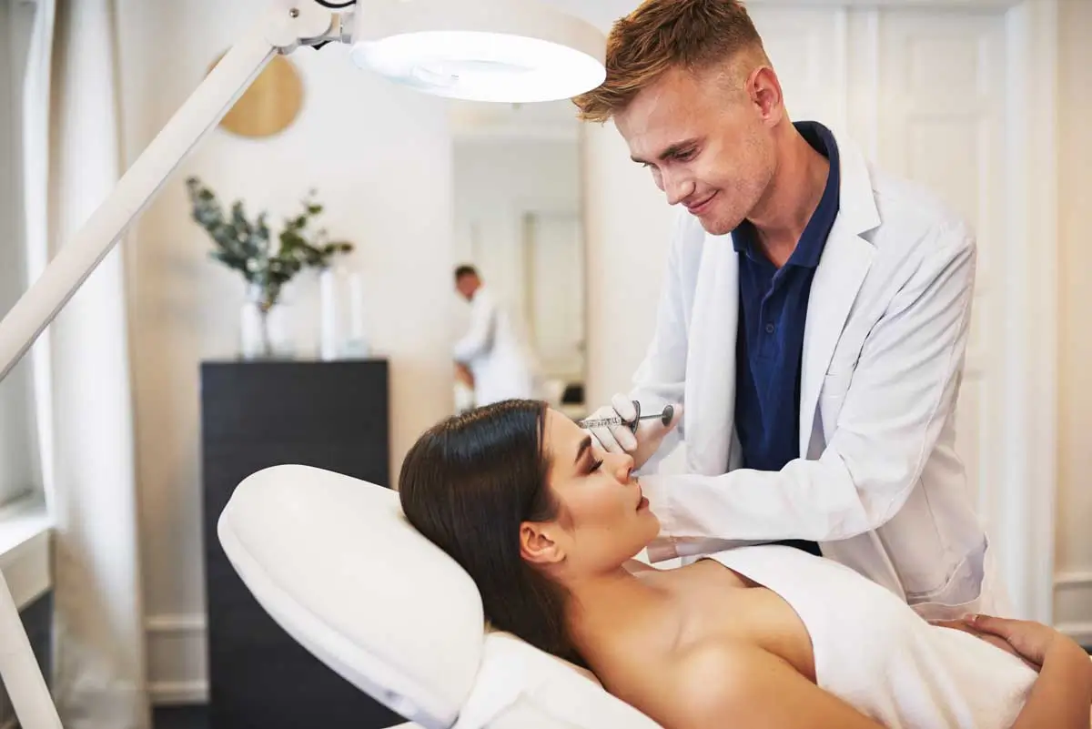 A cosmetic doctor administers a facial injection treatment in a modern aesthetic clinic